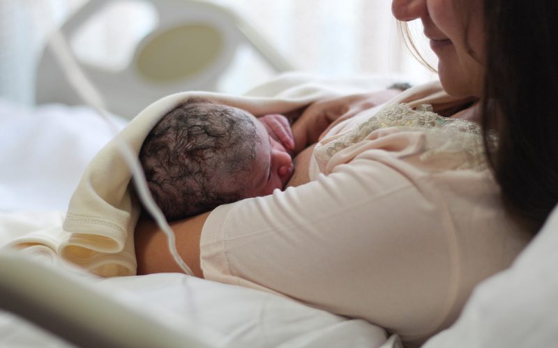 A mother holding her newborn close against her chest
